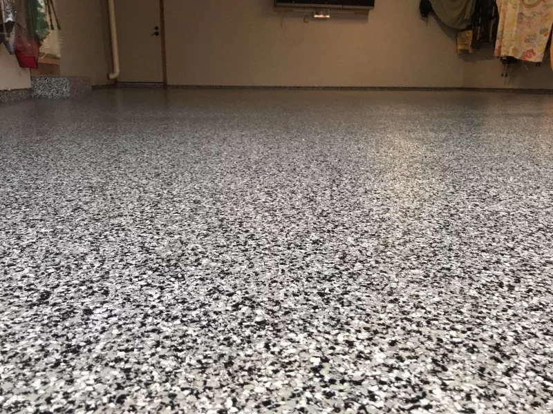 black and white garage floor with epoxy coating and a step and and white door