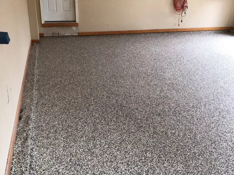 garage floor with epoxy coating and beige walls and extension cord